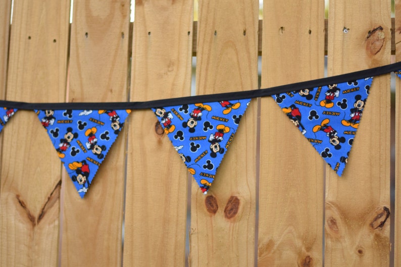 May include: A blue and black Mickey Mouse themed banner with the word "Mickey" printed on each flag.
