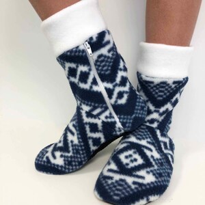 May include: A pair of blue and white fleece slipper socks with a zipper on one sock. The socks have a geometric pattern.