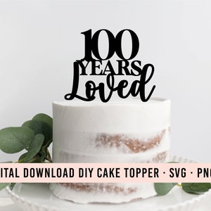 Peut inclure: Décor de gâteau noir avec le texte "100 Years Loved" sur un gâteau blanc.