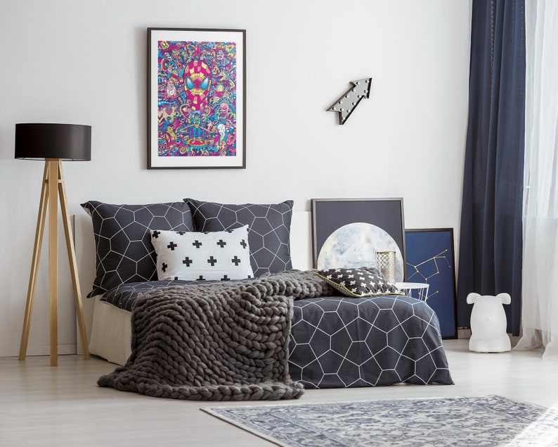Puede incluir: Un edred&oacute;n con estampado geom&eacute;trico en blanco y negro con una manta de punto gris encima. La cama tiene dos almohadas con estampado geom&eacute;trico en blanco y negro y una almohada blanca con cruces negras. Hay una impresi&oacute;n enmarcada de un personaje de dibujos animados de colores sobre la cama.