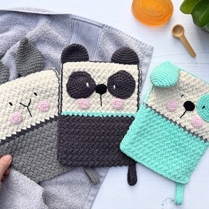 May include: Three crocheted animal-shaped hot pads. A grey and white bunny, a grey and white panda, and a grey, white, and teal dog.