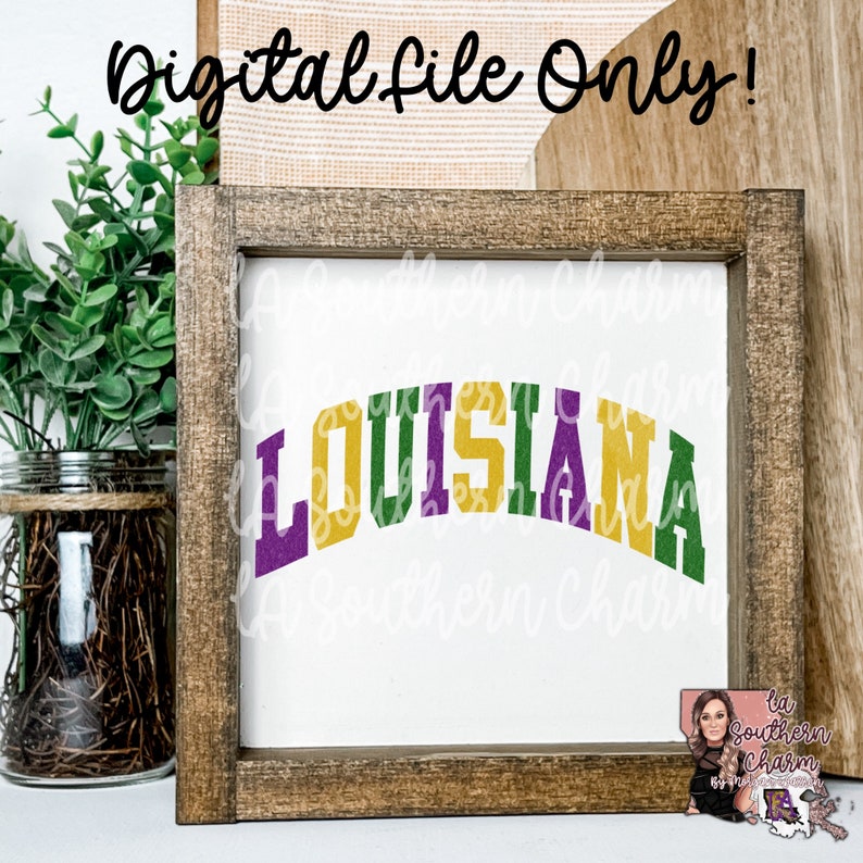 May include: A wooden framed sign with the word "LOUISIANA" in gold, purple, and green letters. The letters are in an arched shape. The sign is on a white background.