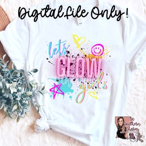 May include: White t-shirt with a colorful graphic design that says "Let's Glow Girls". The design features a pink neon glow, yellow stars, hearts, and a smiley face.