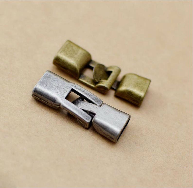 May include: Two metal clasps for jewelry making. One is silver and the other is gold.