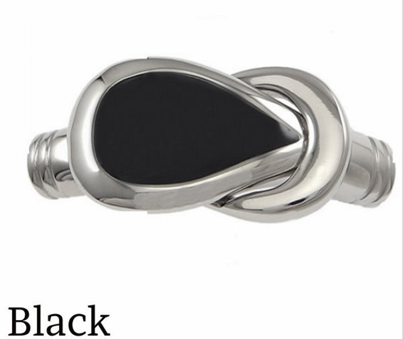 May include: A silver tie clip with a black oval inlay. The tie clip is shaped like a knot.