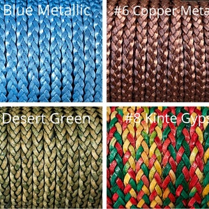 K&ouml;nnte beinhalten: Nahaufnahme von vier geflochtenen Kordeln in verschiedenen Farben. Die Kordeln sind mit den folgenden Farben beschriftet: Blau Metallic, Kupfer Metallic, W&uuml;stengr&uuml;n und Kinte Gypsy. Die Kordeln sind eng gewebt und zeigen ihre Textur und Farbvariationen.
