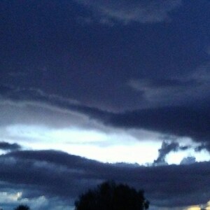 May include: A dark blue sky with a layer of white clouds at the bottom. The clouds are illuminated by the sun, creating a bright white glow.