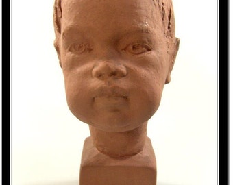 May include: A terracotta bust sculpture of a child with a serious expression. The sculpture is on a square base.