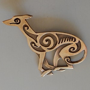 Running greyhound, in profile, facing right, with legs crossed under body.  Body is decorated with cut in Celtic spirals.  Bronze by Master Ark.