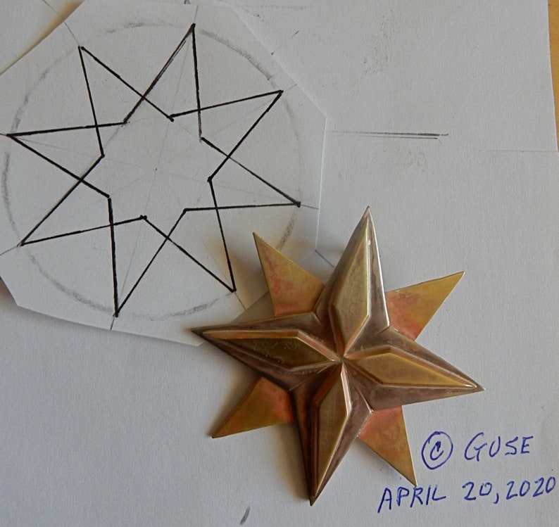 Original soldered eight point star. Four triangular points overlaid by four more points filling in between them. The top four points have a raised elongated diamond shape on top of them. Shown next to original design, copyright Guse, April 20, 2020