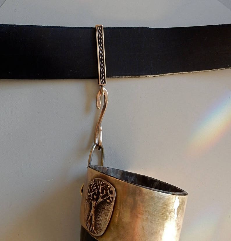 Bronze bar on a belt with a twisted hook attached to the suspension loop at the bottom. A drinking horn is hanging from the  hook.  By Master Ark.