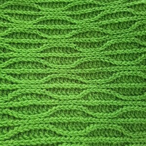 Könnte beinhalten: Nahaufnahme eines hellgrünen Häkelstoffs mit einem strukturierten, wellenartigen Muster. Die Maschen erzeugen eine dichte, optisch ansprechende Oberfläche. Die leuchtende Farbe und die detaillierte Textur deuten auf einen handgefertigten Artikel hin.