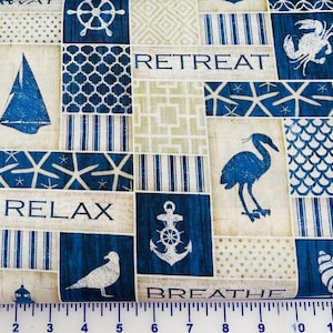 May include: Nautical-themed fabric with a patchwork design. The fabric features blue and white images of anchors, sailboats, compasses, and starfish. The words "RELAX", "RETREAT", and "BREATHE" are also printed on the fabric.