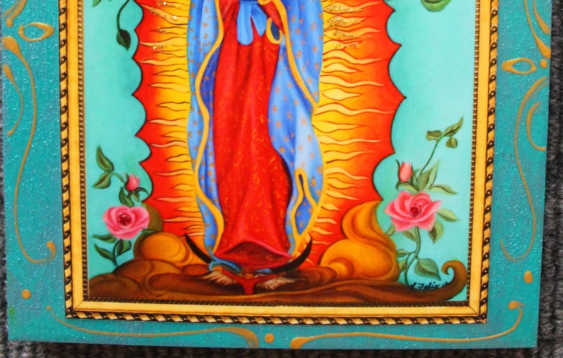 May include: A framed religious painting featuring a central figure in red and blue robes, set against a radiant orange and yellow background. The artwork is bordered by a turquoise frame with floral accents and pink roses.