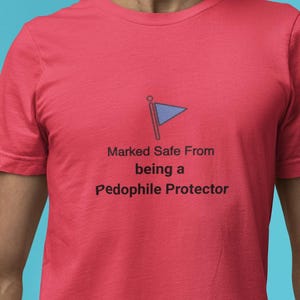 Camiseta con la etiqueta "A salvo de la protección contra pedófilos" y gráfico de la bandera azul.