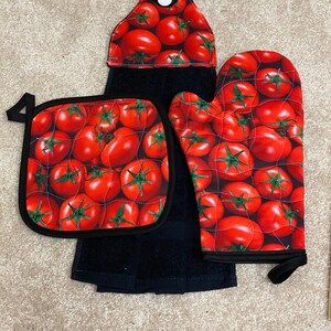 Peut inclure: Un ensemble de trois torchons de cuisine avec un imprimé de tomates rouges. L'ensemble comprend un dessous de plat, un gant de cuisine et une serviette suspendue.