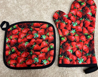Set da cucina con guanti da forno trapuntati e presine isolati con fragole