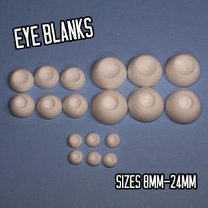 May include: An assortment of off-white eye blanks, displayed on a blue background. The text "EYE BLANKS" and "SIZES 8MM-24MM" are visible. The eye blanks vary in size, from 8mm to 24mm. Ideal for crafting and doll making.