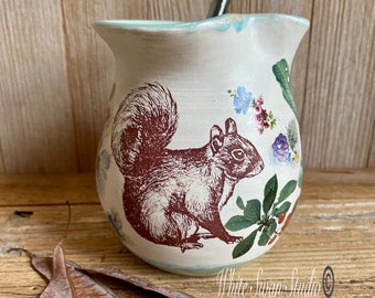 Squirrel and floral little pitcher with wire whisker small mixing pitcher salad dressing server gravy sauce server scrambled eggs.