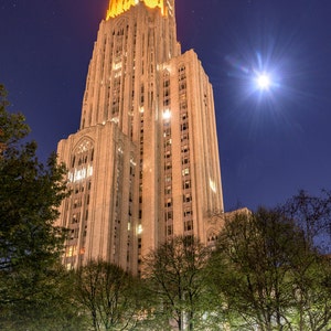 May include: A tall, illuminated building with a pointed roof against a night sky with stars and a bright moon. The building is made of stone and has many windows. The text "NOVEMBER 12, 2016 PITT 43 - CLEMSON 42" is visible at the bottom of the image.