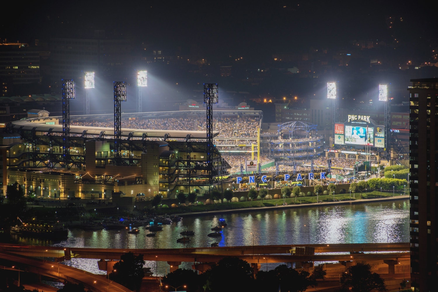 PNC Park is lit up at night during a Pittsburgh Pirates game - Metal Print