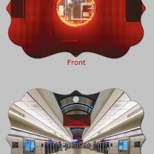 May include: Ornament with a red front featuring a circular neon light and a back view of a subway station. The front has a red wall with a circular neon light. The back shows a long subway platform with benches and digital displays.