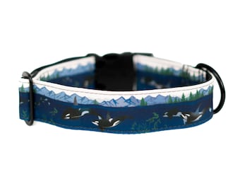 Puede incluir: Un collar para perro azul y blanco con una hebilla negra y un patrón de orcas nadando en el océano con montañas en el fondo.