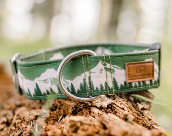 May include: Green dog collar with a mountain and forest print. The collar has a silver D-ring and a brown leather patch with the text "GRAY+HOUND".