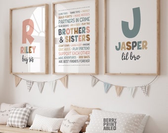 May include: Three framed prints with names and phrases in a child's room. The prints feature the names "Riley" and "Jasper", and a list of phrases like "Brothers & Sisters". A large woven giraffe and storage bench with bins are also in the room.