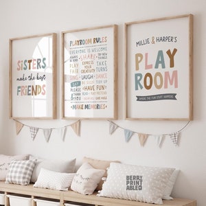 May include: Three framed prints with colourful text on a white background. The first print says "Sisters make the best friends". The second print says "Playroom Rules" and lists rules for playing nicely. The third print says "Millie & Harper's Playroom" with a banner underneath that says "Where the fun stuff happens".