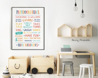 Puede incluir: Un póster imprimible colorido con el texto "Reglas de la sala de juegos" y una lista de reglas para niños, que incluyen "Compartir", "Ser amable", "Jugar limpio", "Divertirse" y "Crear recuerdos". El póster está enmarcado y colgado en una pared blanca en un entorno de sala de juegos.