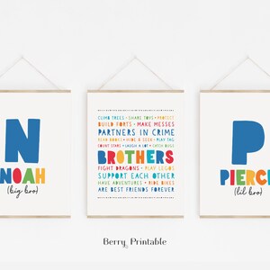 May include: Two colorful prints with the names Noah and Pierce, with the text "big bro" and "lil bro" underneath. The prints feature the first letter of each name in a large blue font, with the rest of the name in a rainbow font. The middle print features a list of things brothers do together, such as "climb trees", "share toys", "build forts", "make messes", "partners in crime", "read books", "hide and seek", "play tag", "count stars", "laugh a lot", "catch bugs", "fight dragons", "play legos", "support each other", "have adventures", "ride bikes", and "are best friends forever".