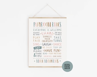 May include: A framed playroom rules print with a light wood frame. The print features colorful text including "Playroom Rules", "Make Memories", and other positive affirmations. The print is designed to be hung on a wall.