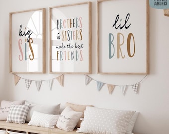 May include: Three framed prints with text: "big sis", "Brothers & Sisters make the best FRIENDS", and "lil BRO". The prints have a light wood frame and colorful text. A garland of small flags hangs below the prints, and pillows rest on a wooden bench.