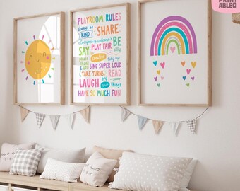 May include: Three framed art prints with a playful theme. One features a smiling sun, another displays "Playroom Rules", and the third showcases a colorful rainbow with hearts. The prints are in wooden frames, and a banner of small flags hangs below.