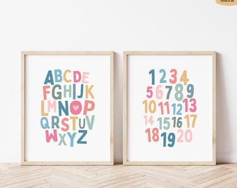 May include: Two framed prints with colorful letters and numbers. The left print displays the alphabet in various colors, while the right print shows numbers 1 through 20. Both prints have a white background and are in light wood frames.