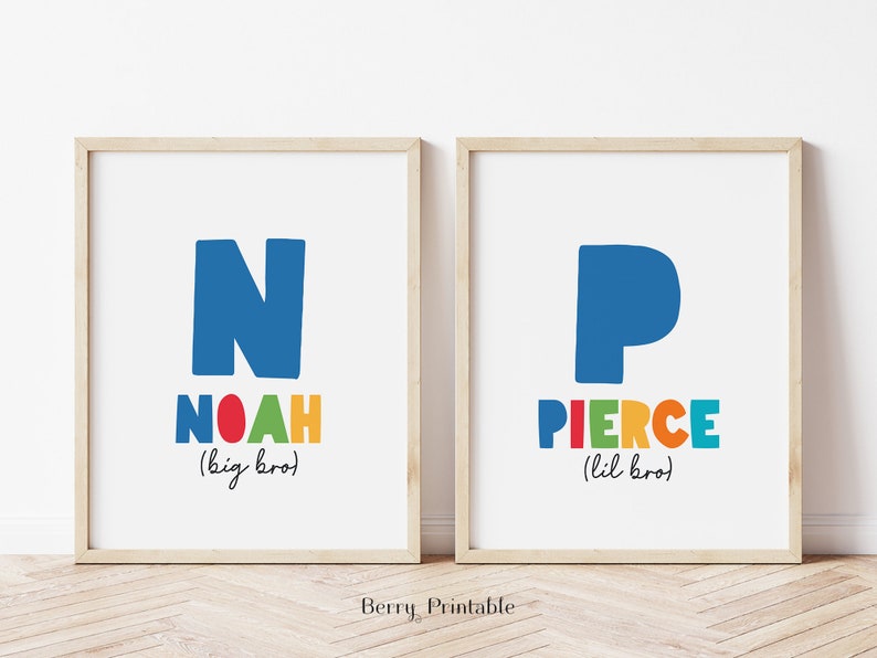 May include: Two framed prints with colorful letters spelling out the names Noah and Pierce. The prints are on a white background and have the words "big bro" and "lil bro" written below the names.