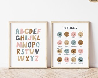 May include: Two framed prints. One displays the alphabet in pastel colors. The other print features a chart of feelings with corresponding emoji faces. The word "FEELINGS" is at the top of the second print.
