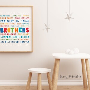 May include: A framed print with a white background and colorful text that reads "Climb trees, share toys, protect, build forts, make messes, partners in crime, read books, hide & seek, play tag, count stars, laugh a lot, catch bugs, brothers, fight dragons, play legos, support each other, have adventures, ride bikes, are best friends forever".