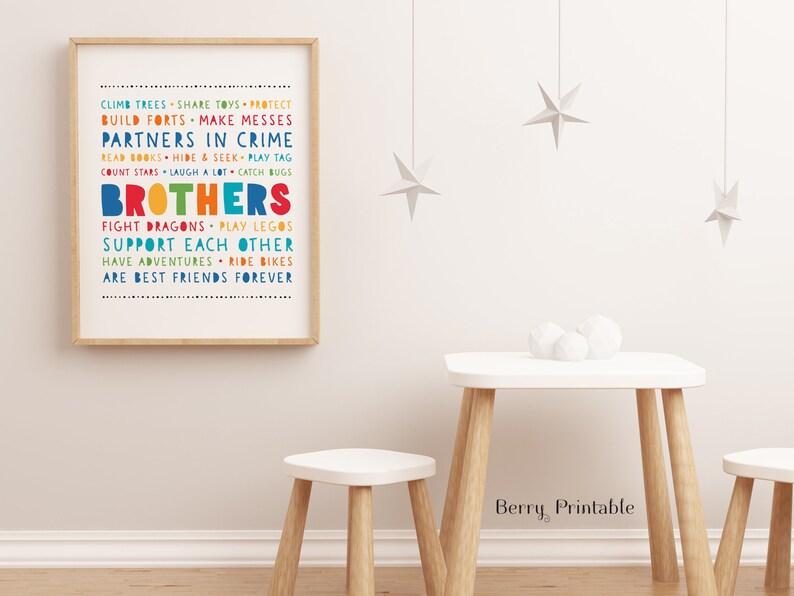 May include: A framed print with a white background and colorful text that reads "Climb trees, share toys, protect, build forts, make messes, partners in crime, read books, hide & seek, play tag, count stars, laugh a lot, catch bugs, brothers, fight dragons, play legos, support each other, have adventures, ride bikes, are best friends forever".