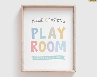 May include: A framed wall print featuring the text Millie & Easton's PLAY ROOM in colorful pastel letters, with the phrase WHERE THE FUN STUFF HAPPENS printed on a light blue banner at the bottom, all set against a clean white background.