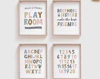 May include: Four framed wall art prints with light wood frames. The prints feature colorful typography in muted tones of blue, pink, and brown. The designs include text reading Millie & Ethan's Playroom, Brothers & Sisters make the best friends, the alphabet, and numbers one through twenty.
