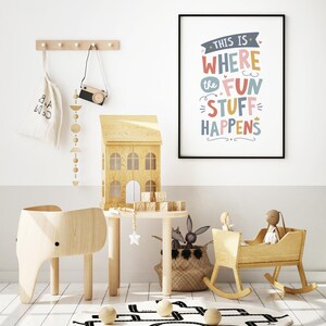 May include: A child's playroom with wooden furniture and toys. Includes a wooden elephant chair, a dollhouse, a rocking cradle, and a round rug with a road design. A framed print reads "THIS IS WHERE THE FUN STUFF HAPPENS."