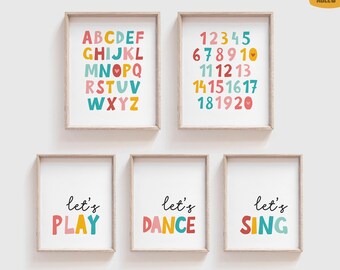 May include: Five framed prints with colorful text and illustrations. Two prints display the alphabet and numbers. The other three read "let's PLAY", "let's DANCE", and "let's SING". The prints have a white background and are in light brown frames.