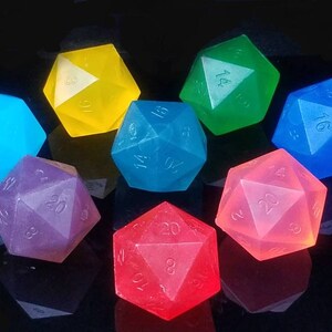 May include: A collection of colorful, twenty-sided dice in various colors, including blue, yellow, green, and red. Each die has visible numbers and a translucent appearance, with a reflective surface.