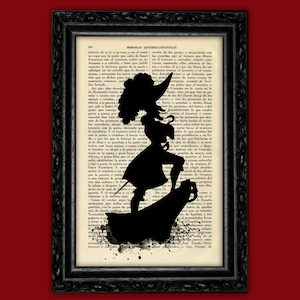 Puede incluir: Una silueta negra de una bruja de pie sobre una roca con un libro de texto detrás de ella. La silueta está rodeada de salpicaduras de tinta negra.