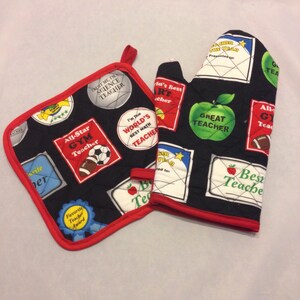 Könnte beinhalten: Ein Set aus zwei schwarzen und roten Ofenhandschuhen mit gestepptem Design. Die Handschuhe haben verschiedene bunte Patches mit Text, der "Bester Lehrer", "Toller Lehrer", "All-Star-Turnlehrer", "Weltbester Mathematiklehrer", "Vertrauen Sie mir, ich bin ein Naturwissenschaftslehrer" und "Preis für den Lieblingslehrer" lautet.