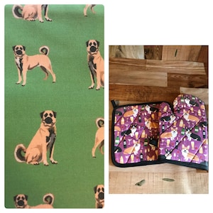 May include: A set of two kitchen pot holders featuring a purple background with a repeating pattern of black and white corgis, wine bottles, and wine glasses. The pot holders are black and white with a black border.