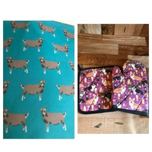 May include: A set of two purple and black oven mitts and a pot holder with a pattern of corgis drinking wine. The background is a wood surface.