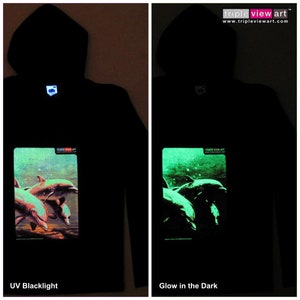 Könnte beinhalten: Schwarzer Kapuzenpullover mit einem Motiv von Delfinen, die im Meer schwimmen. Das Motiv leuchtet unter Schwarzlicht grün.